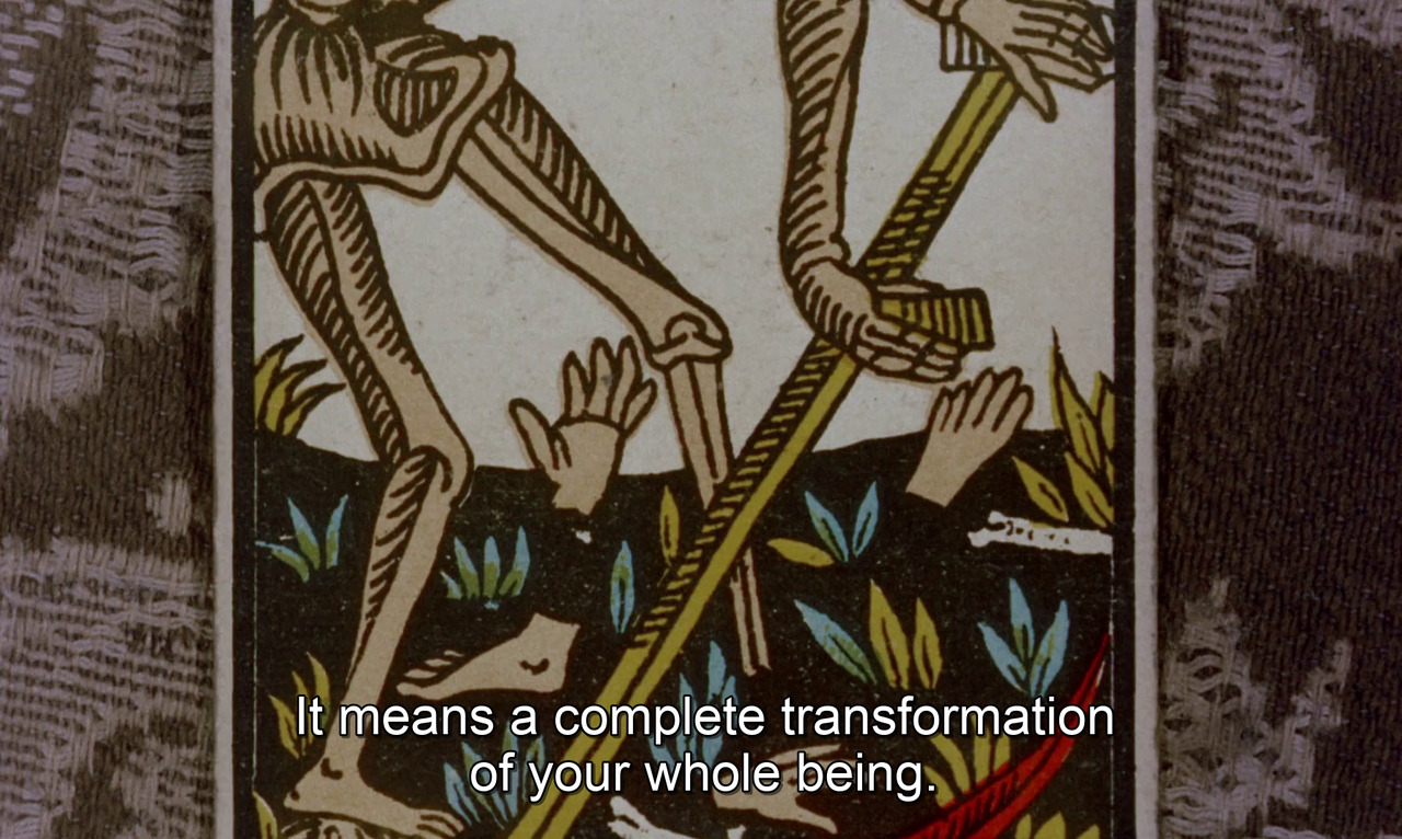 Film still showing the top half of the Death tarot card with white subtitles that read 'It means a complete transformation of your while being.'